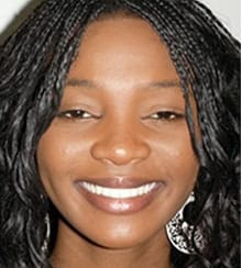 A smiling woman with braided hair without crossbite