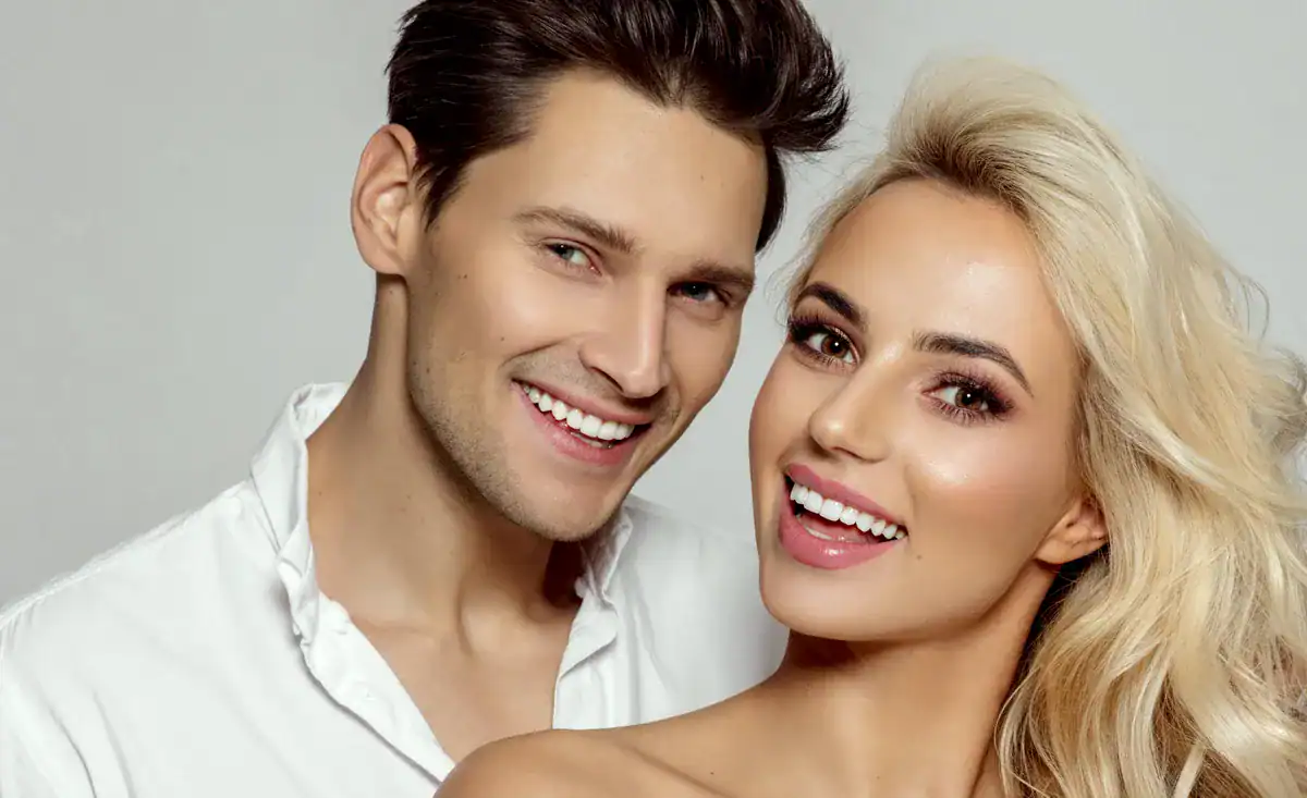 A smiling couple with perfect teeth, representing dental health and cosmetic dentistry.