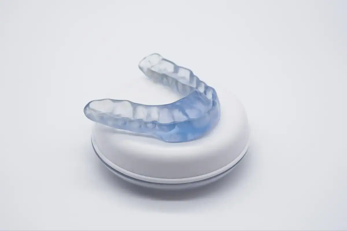 A clear dental mouthguard on a white surface for teeth protection.